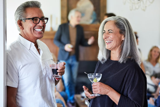 Senior Couple with group of friends and family having a cocktail party in their home - Powered by Adobe