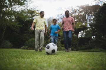 Obraz na płótnie Canvas Multi-generation family playing soccer together at park