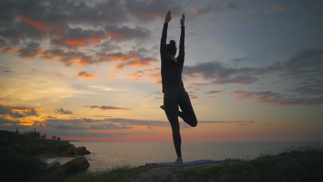 Peaceful woman practice yoga pose meditate daylight coast uttanasana slow motion