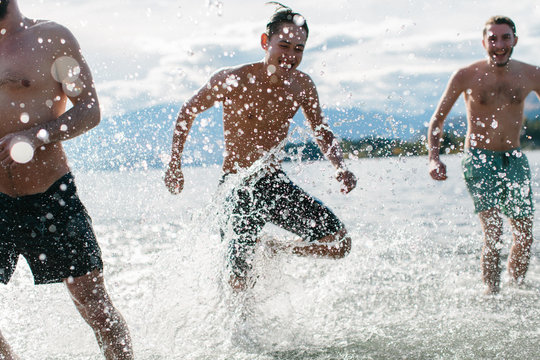 Three friends splash around in the warm waters of a lake on a late summer day 
