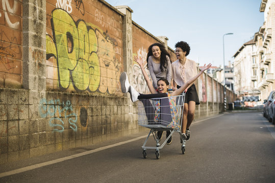 Young Black Women Having Fun On A Shopping Cart In The City