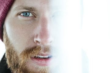 Portrait of a young man with a beard and blue eyes
