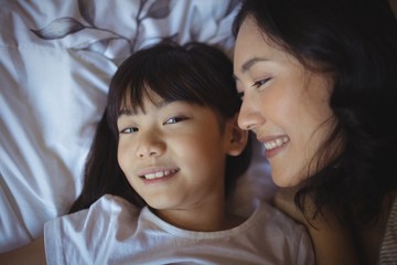 Obraz premium Mother and daughter relaxing on bed in bed room