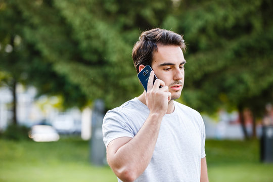 Serious man at park takling on phone