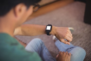 Man using smart watch in living room