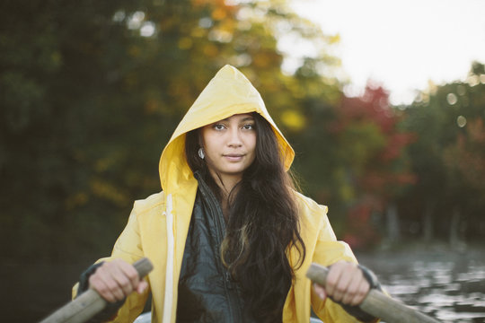 Young brunette girl wearing a yellow rain jacket on a fall day