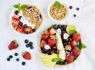 Yogurt with granola and fruits, blueberries, strawberries, cherry, apple, banana, healthy breakfast