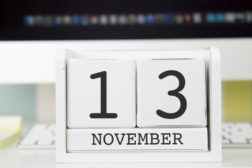 Cube shape calendar for NOVEMBER 13 and computer keyboard on table. 