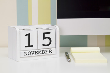 Cube shape calendar for NOVEMBER 15 and computer keyboard on table. 