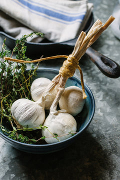 Garlic bulbs and thyme in a bowl