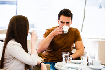 Young couple in caffe drinking coffe and talking