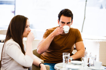 Young couple in caffe drinking coffe and talking