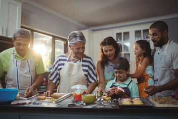 Happy family preparing dessert in kitchen - Powered by Adobe