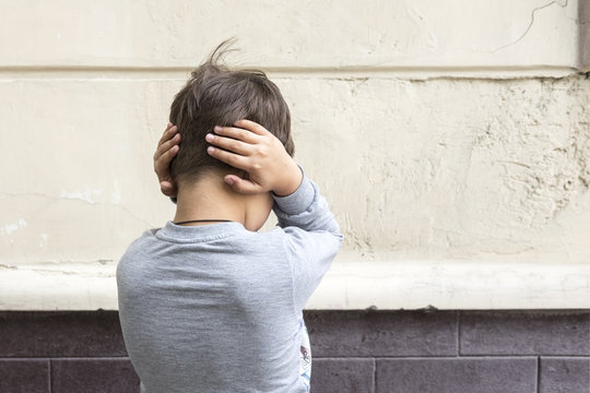 Young Boy Closes Ears With Hands. Behavior, Attitude Concept