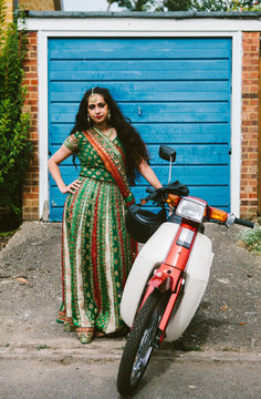 Beautiful Indian woman wearing a sari and with a moped