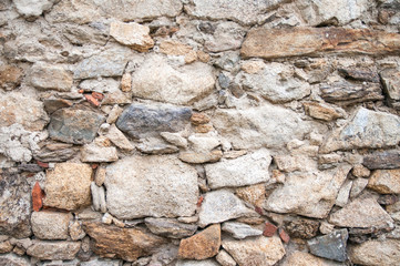 Old beige stone wall background texture close up