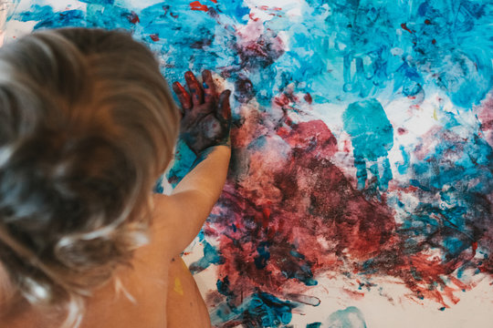toddler painting on canvas from above