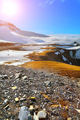 The top of the mountains, snowy peaks, sun, clouds