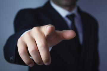 Businessman pointing finger at you.