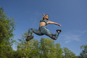 Fit young girl posing for camera during outdoor gym exercises