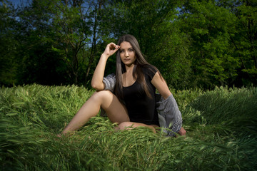 Fit young girl in bodysuit posing in a grass field