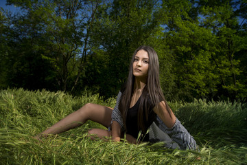 Fit young girl in bodysuit posing in a grass field
