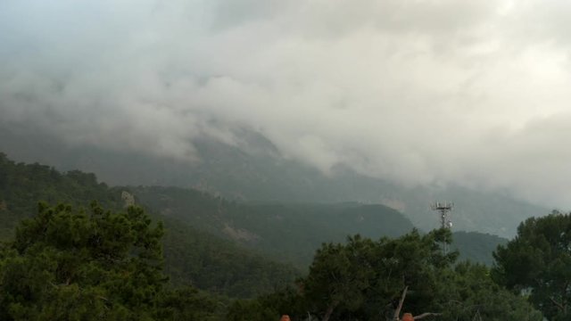 Timelapse clouds fly near the top of the mountains