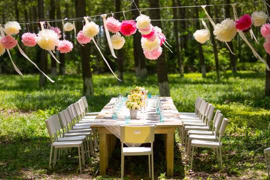 Decorated table and chairs arranged in forest for the party