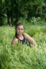 Naklejka na ściany i meble Portrait of a young girl in a grass field 