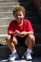 Boy sitting on staircase in the boot camp on a sunny day