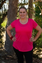 Happy woman standing with hands on hip in the boot camp