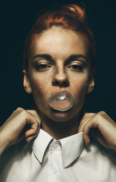 Fashionable/conceptual  portrait of hip young ginger female with bubble gum