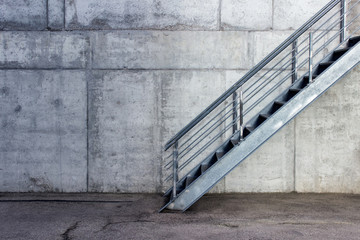 Fototapety  Metalowe schody na tle szarej ściany cementu - miejski minimalistyczny na zewnątrz.