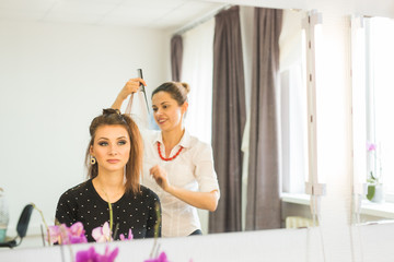 Obraz premium Hairdresser doing haircut for women in hairdressing salon. Concept of fashion and beauty. Positive emotion.