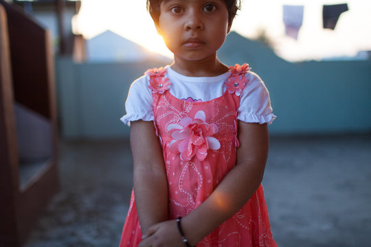 Back light portrait of little girl standing in a serious mood