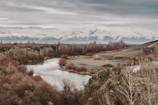 river flowing through snowcovered mountain landscape surrounded by colorful forest