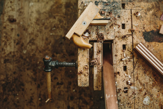 old and used workbench with a bench vice, wood plane and wood chips from above