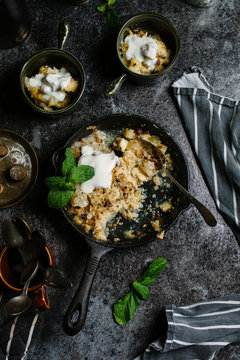Pear, hazelnut and toffee crumble in a skillet on a dark background