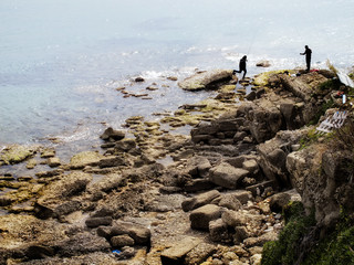 fisherman at rocky beach