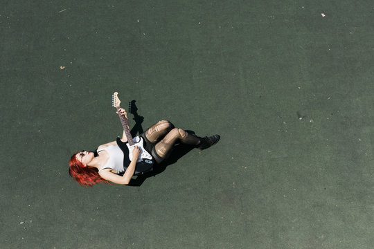 punk young woman playing with  guitar