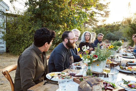 Group of friends enjoying a Farm To Table Dinner Party in backyard