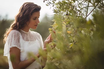 Foto op Plexiglas Olijfboom Mooie jonge vrouw met olijfboom op boerderij