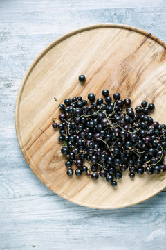 Fresh blackcurrants on a wooden plate