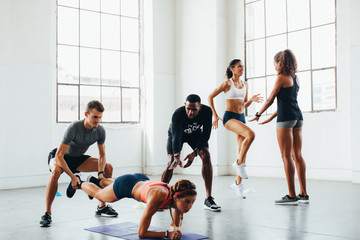 Young multiethnic teamwork doing exercises at indoors bootcamp 