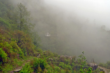 Fototapeta na wymiar Little temple on hill in fog near Landruk, Annapurna Conservation Area, Himalaya Mountains