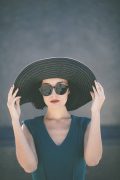 trendy young woman wearing hat and retro sunglasses