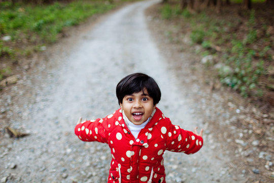 Happy child on a gravel road in the forest