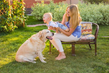 Family Relaxing In Garden With Pet Dog