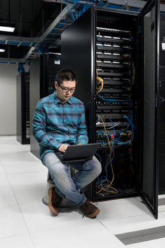 Engineer working on laptop in data center