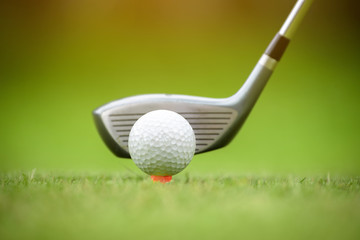 Golf balls and golf club on green grass